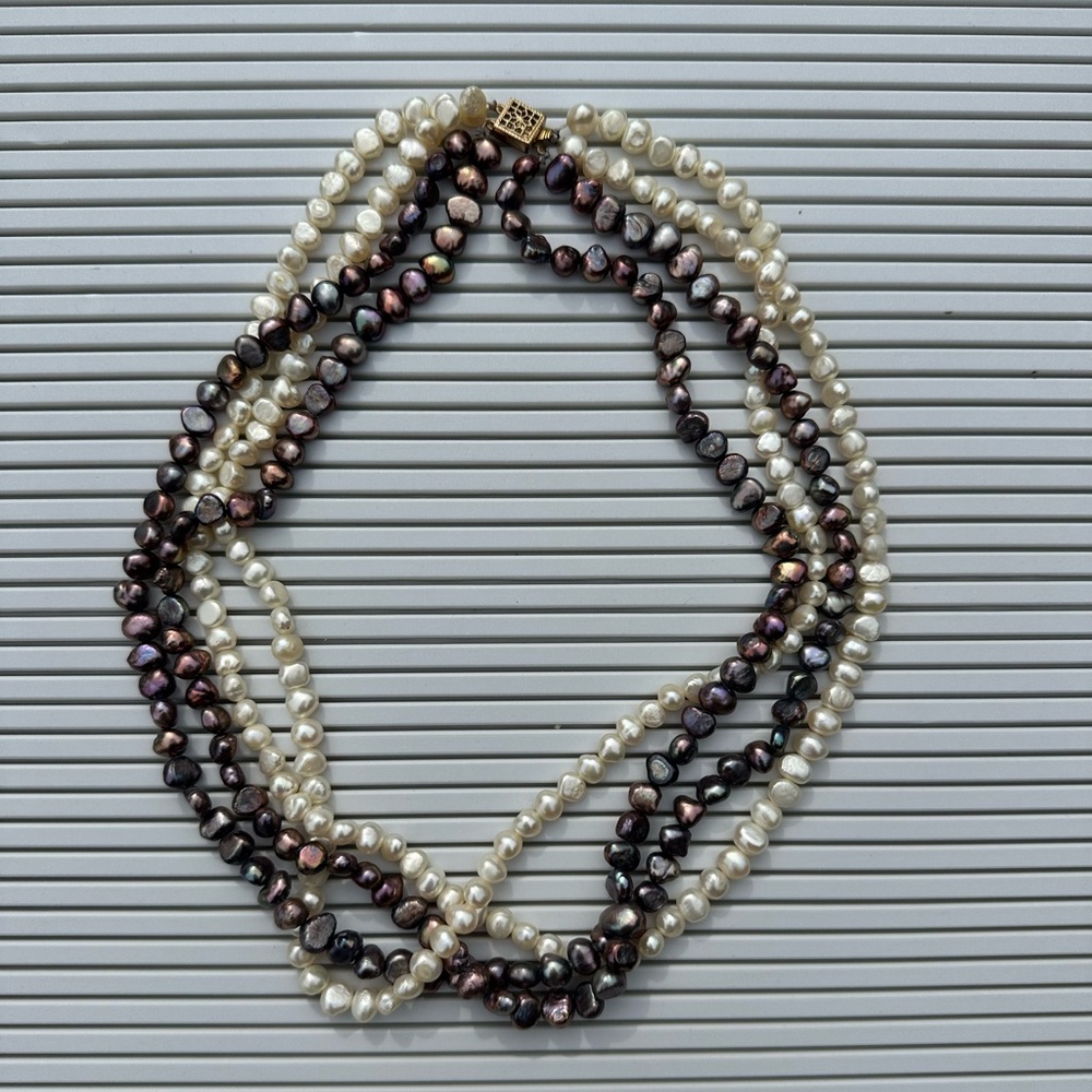 4 strand off white and purplish metallic bead necklace.